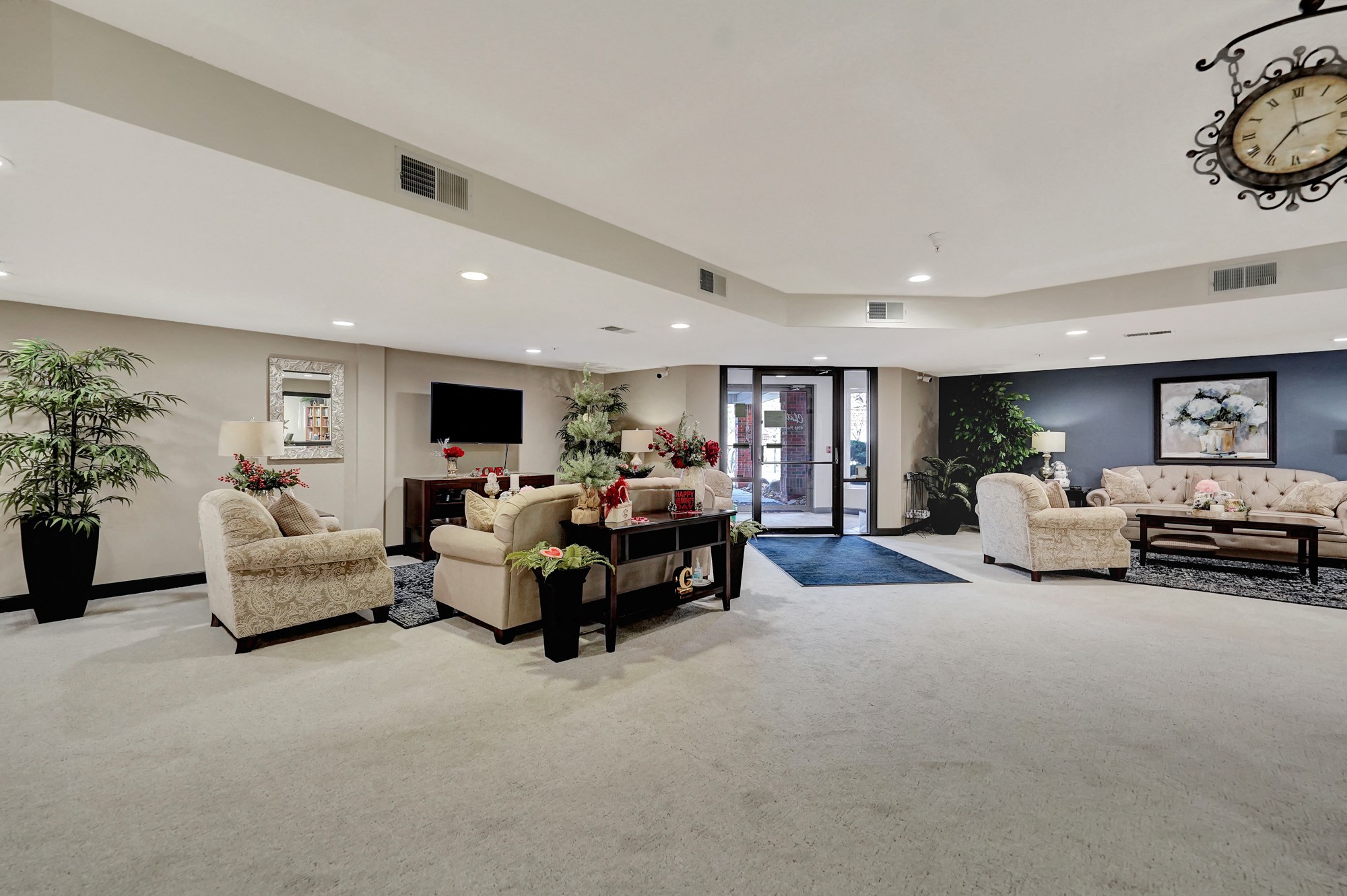 a large living room with couches and chairs and a clock on the wall